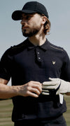 Lyle & Scott Golf Collection. Men's Polo Shirts, Accessories. Man wearing black Lyle & Scott Golf Polo Shirt.