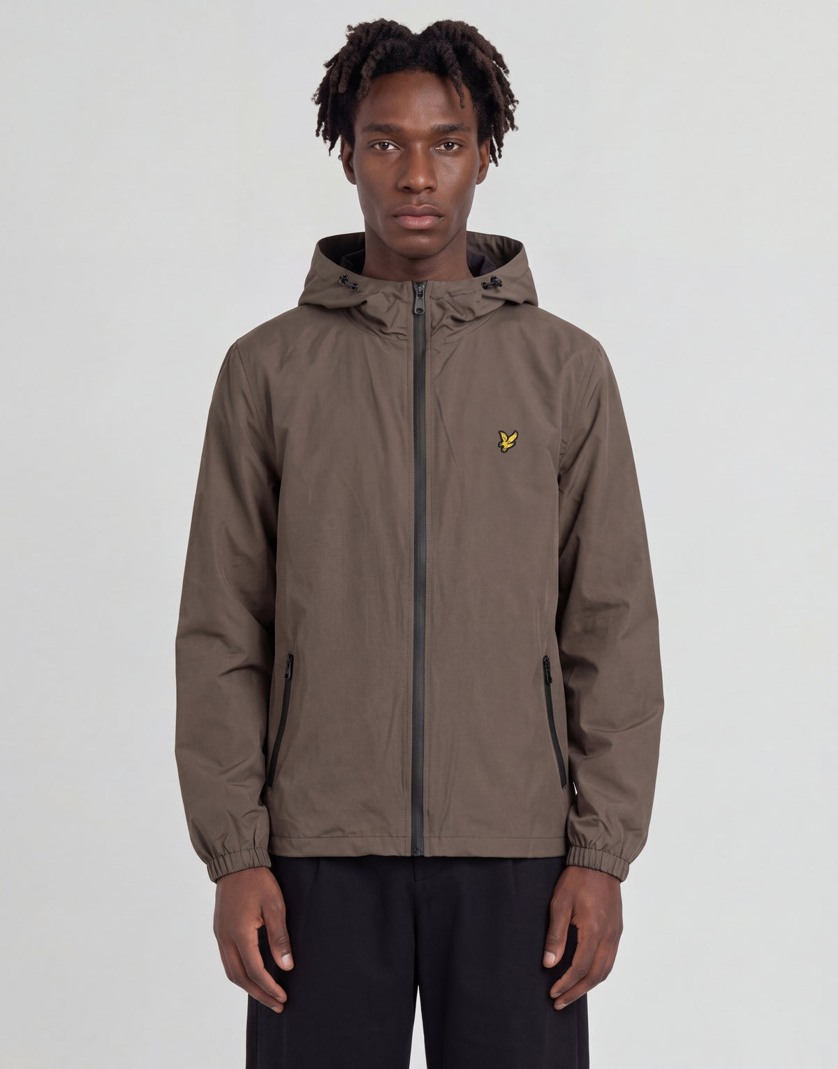 Mann trägt eine „Active Technical Windbreaker“-Jacke in der Farbe „Khaki Ash“