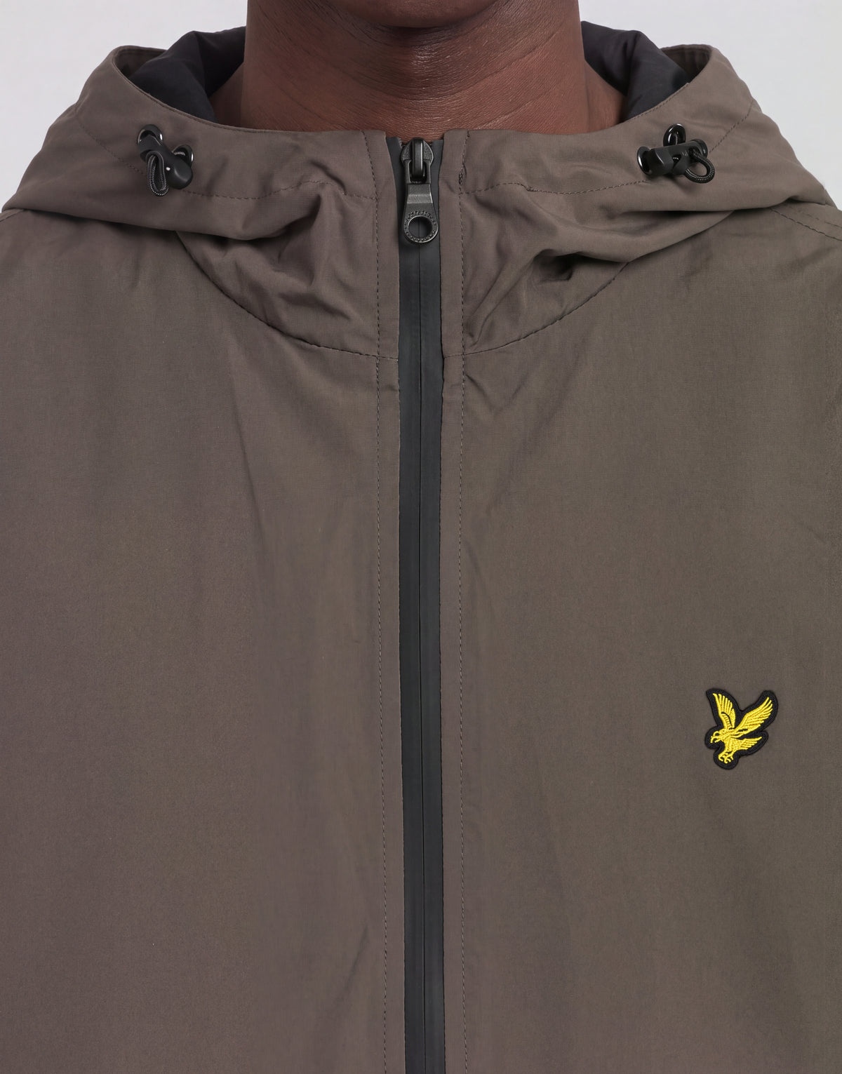 Mann trägt eine „Active Technical Windbreaker“-Jacke in der Farbe „Khaki Ash“