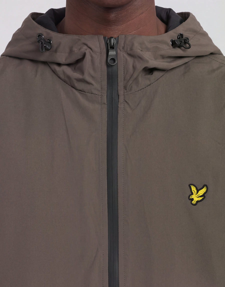 Mann trägt eine „Active Technical Windbreaker“-Jacke in der Farbe „Khaki Ash“
