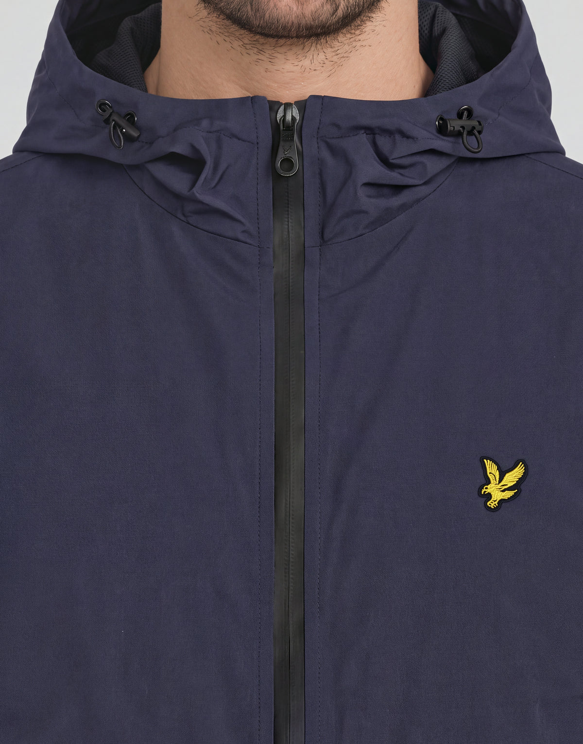 Mann trägt eine „Active Technical Windbreaker“-Jacke in Dunkelblau