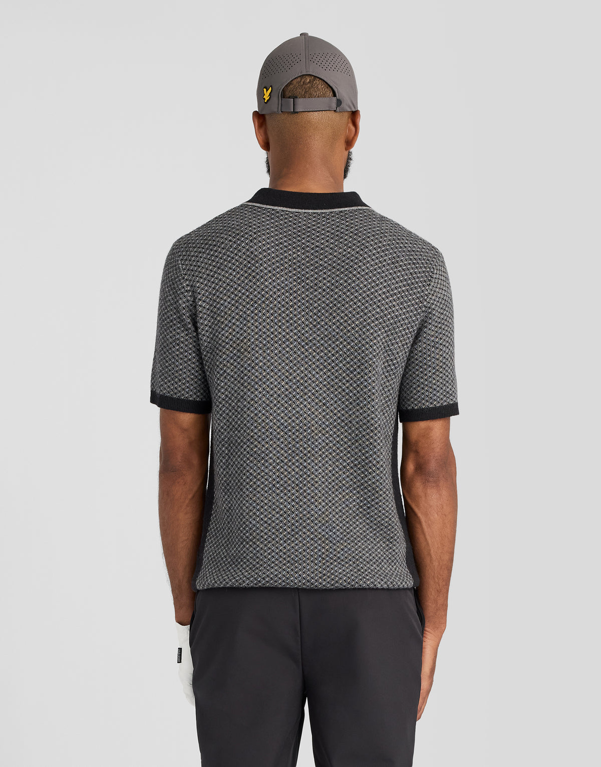 Hombre con un polo de mezcla de cachemira con estampado de rayas cruzadas en negro azabache