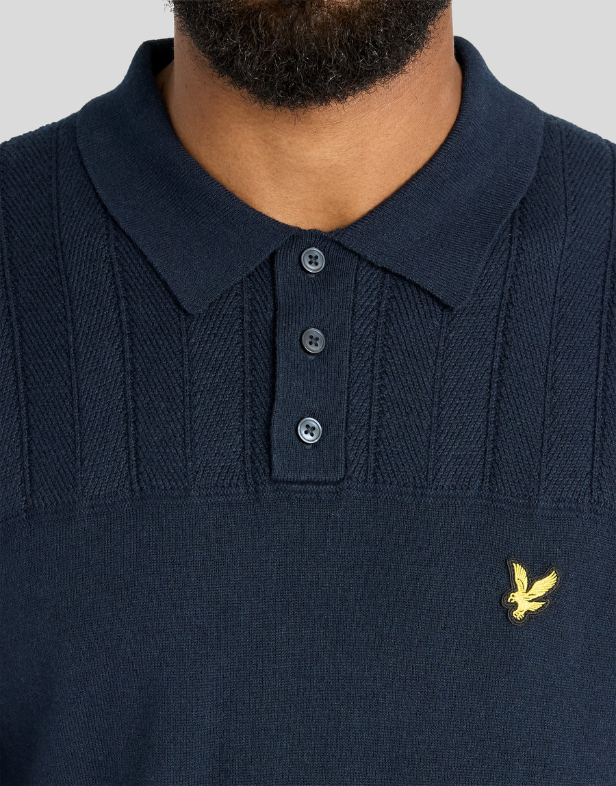 Man in een gebreid poloshirt met textuurblokpatroon in donker marineblauw