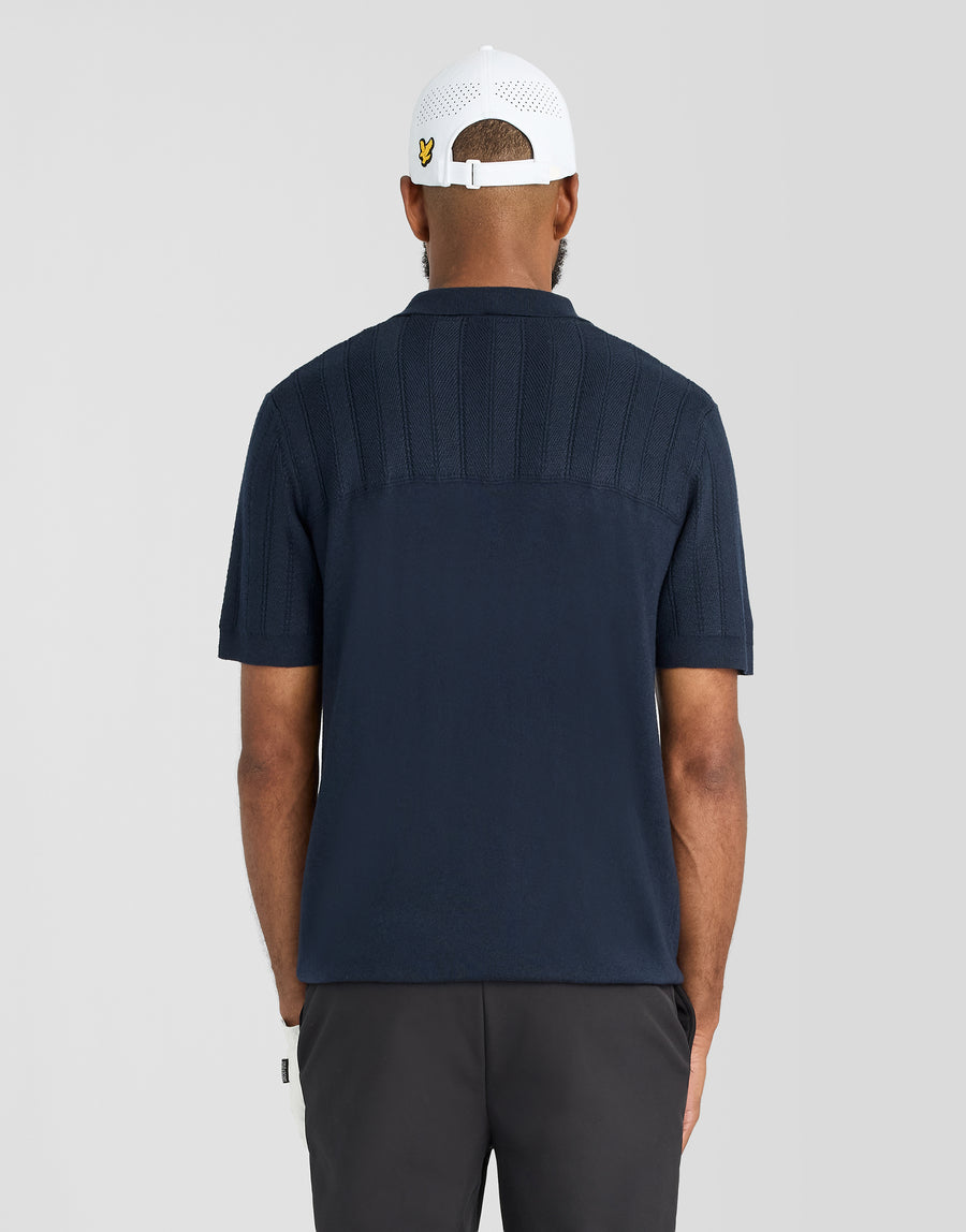 Man in een gebreid poloshirt met textuurblokpatroon in donker marineblauw