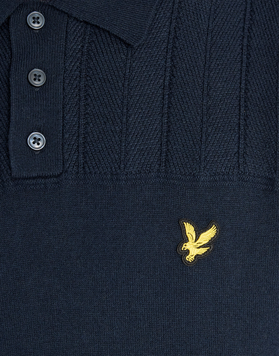 Man in een gebreid poloshirt met textuurblokpatroon in donker marineblauw