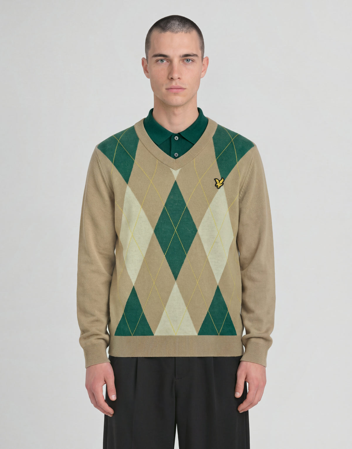 Man wears Archive Argyle Knitted V-Neck Jumper in Camel Taupe