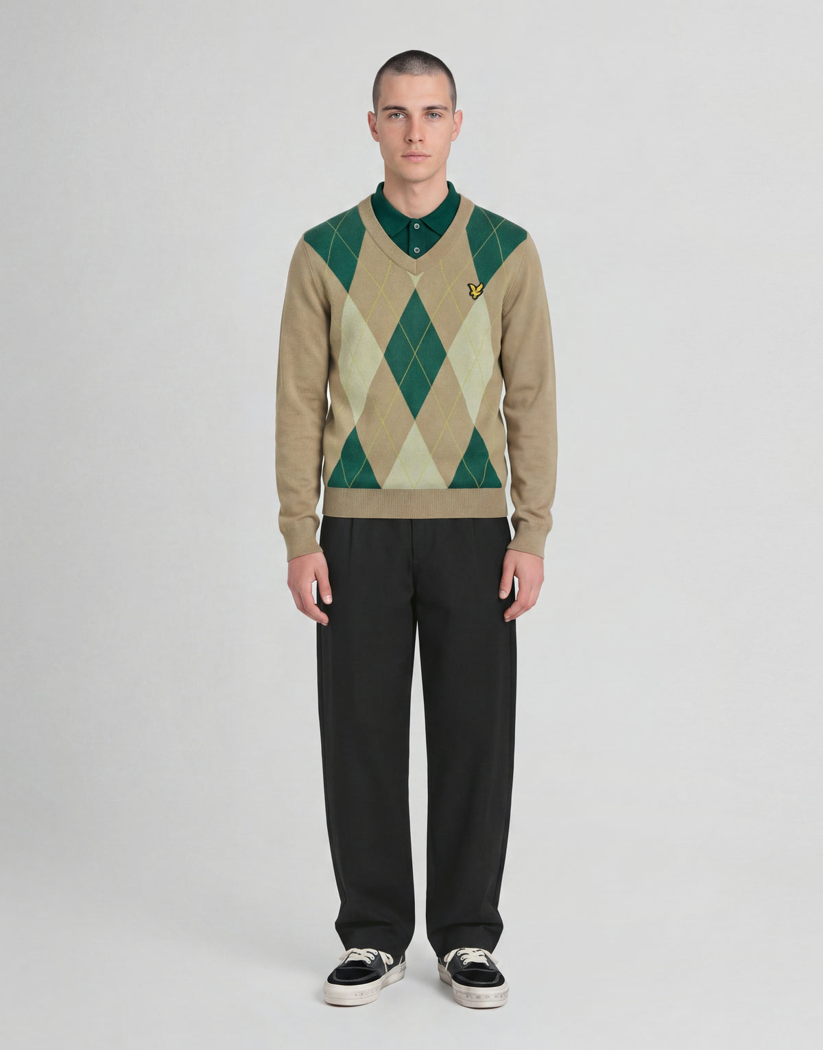 Man wears Archive Argyle Knitted V-Neck Jumper in Camel Taupe