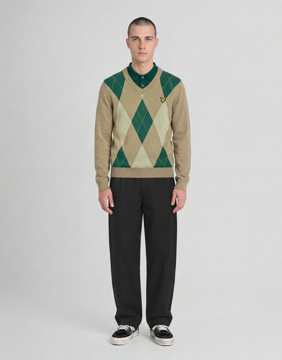 Man wears Archive Argyle Knitted V-Neck Jumper in Camel Taupe