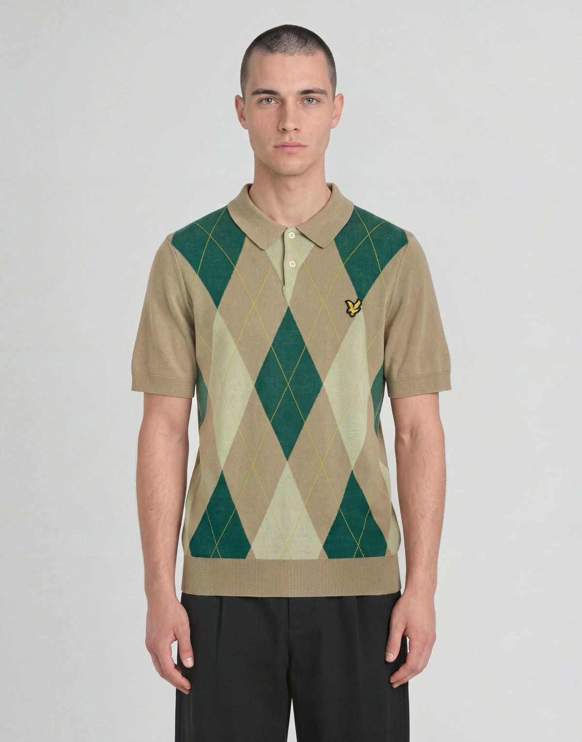 Mann trägt ein gestricktes Polohemd „Archive Argyle“ in der Farbe „Camel Taupe“