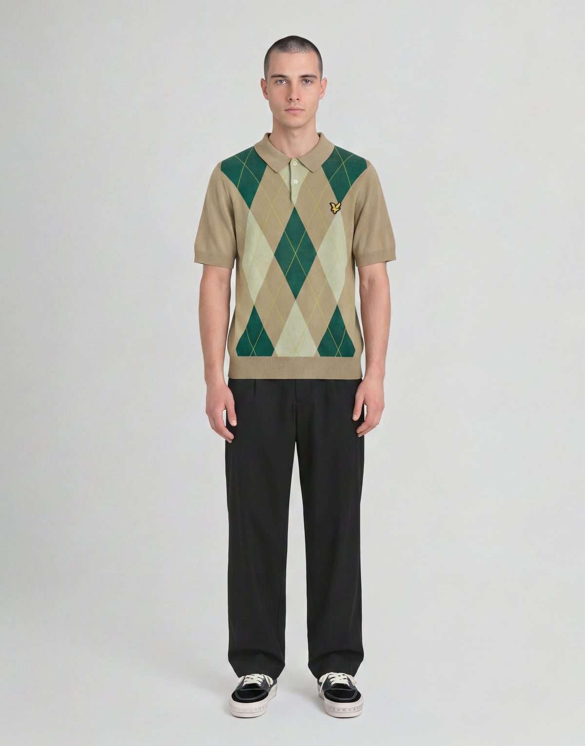 Mann trägt ein gestricktes Polohemd „Archive Argyle“ in der Farbe „Camel Taupe“
