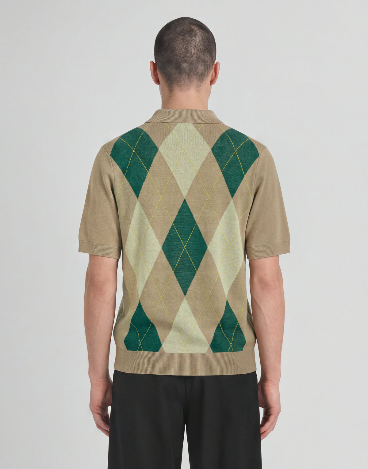Mann trägt ein gestricktes Polohemd „Archive Argyle“ in der Farbe „Camel Taupe“