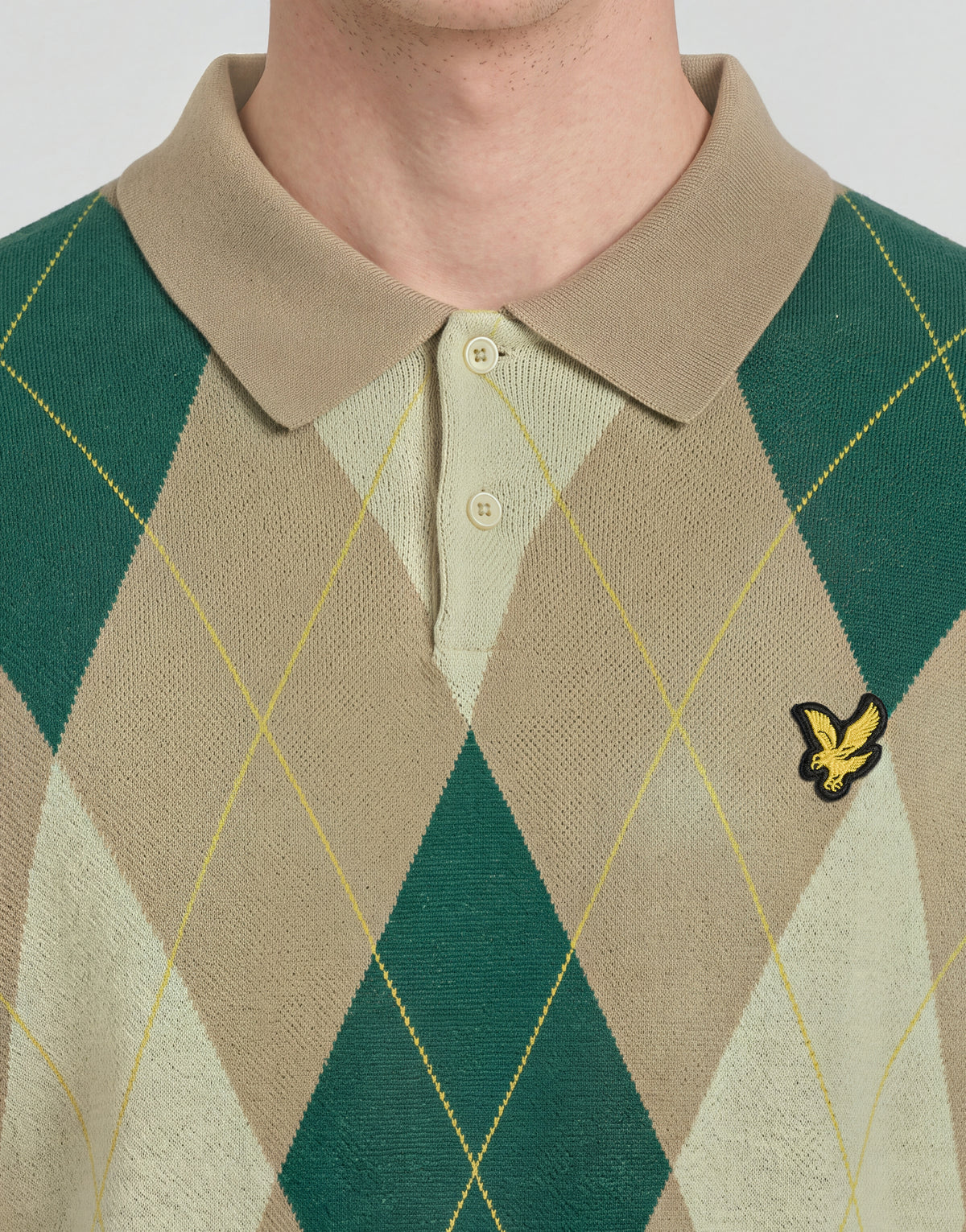 Mann trägt ein gestricktes Polohemd „Archive Argyle“ in der Farbe „Camel Taupe“