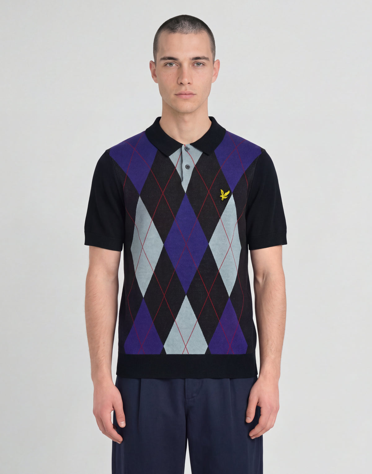 Man wears Archive Argyle Knitted Polo Shirt in Dark Navy