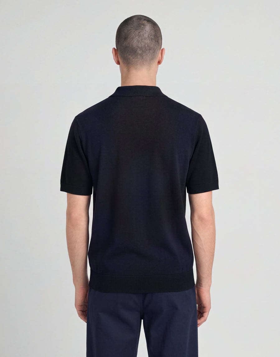 Man wears Archive Argyle Knitted Polo Shirt in Dark Navy