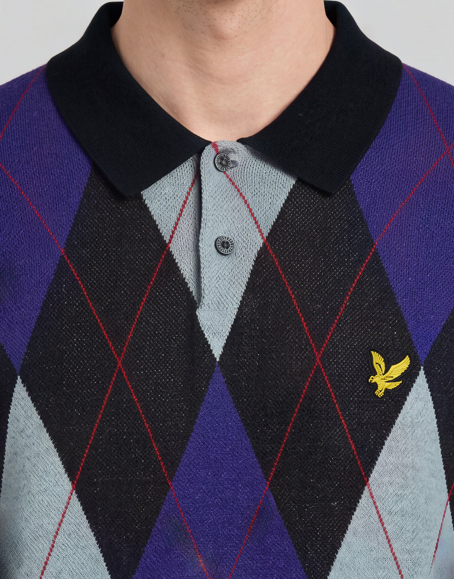 Man wears Archive Argyle Knitted Polo Shirt in Dark Navy