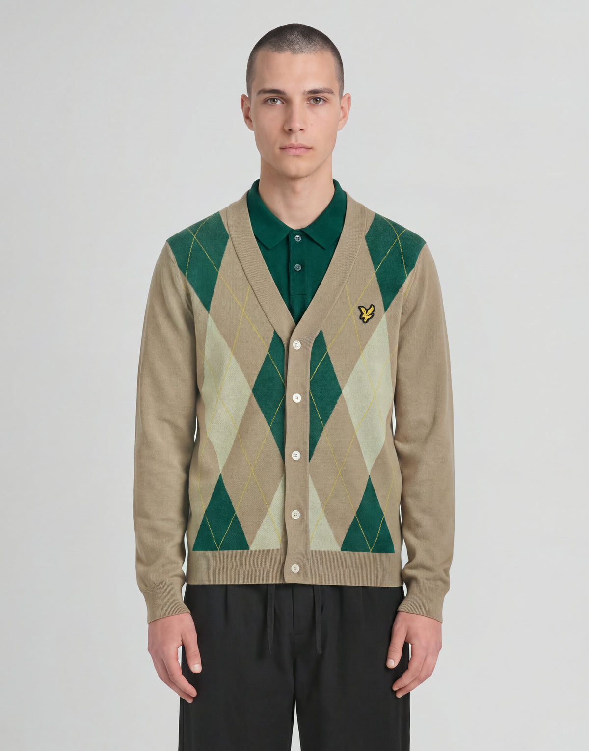 Man wears Archive Argyle Knitted Cardigan in Camel Taupe
