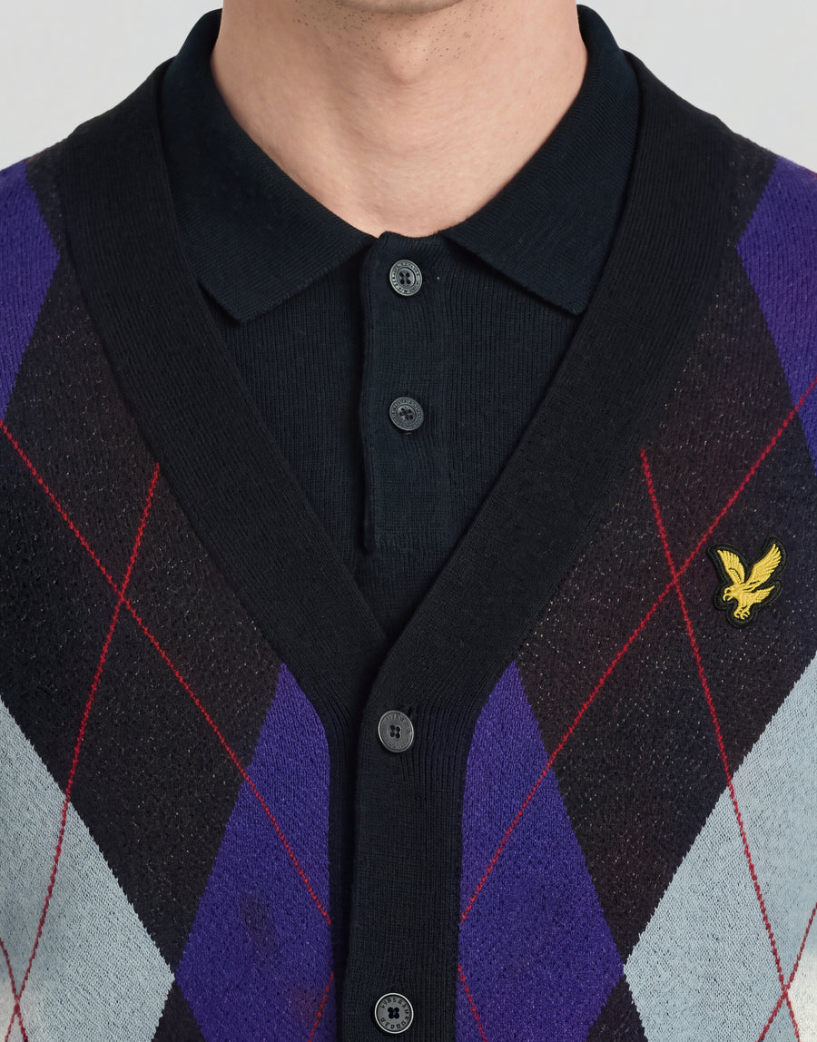 Mann trägt eine gestrickte Strickjacke „Archive Argyle“ in Dunkelblau