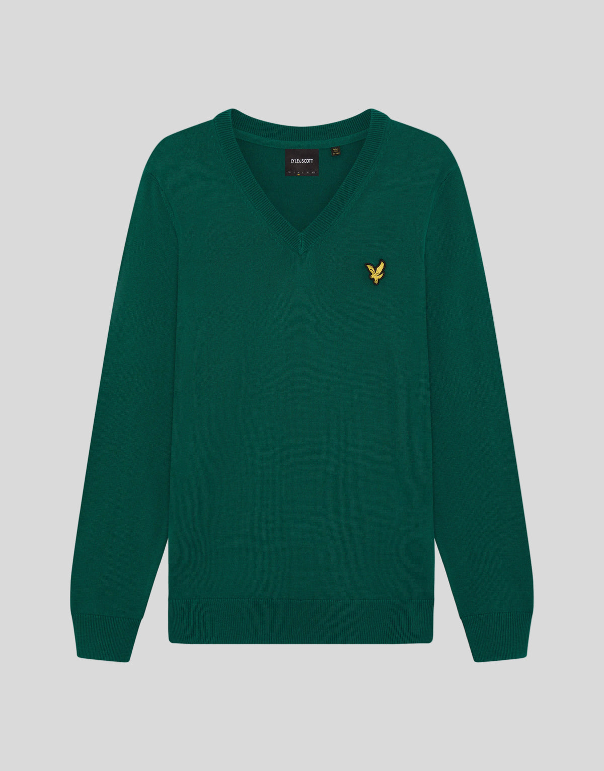 Man draagt een gebreide trui met V-hals uit de Archive-collectie onder een groene jas