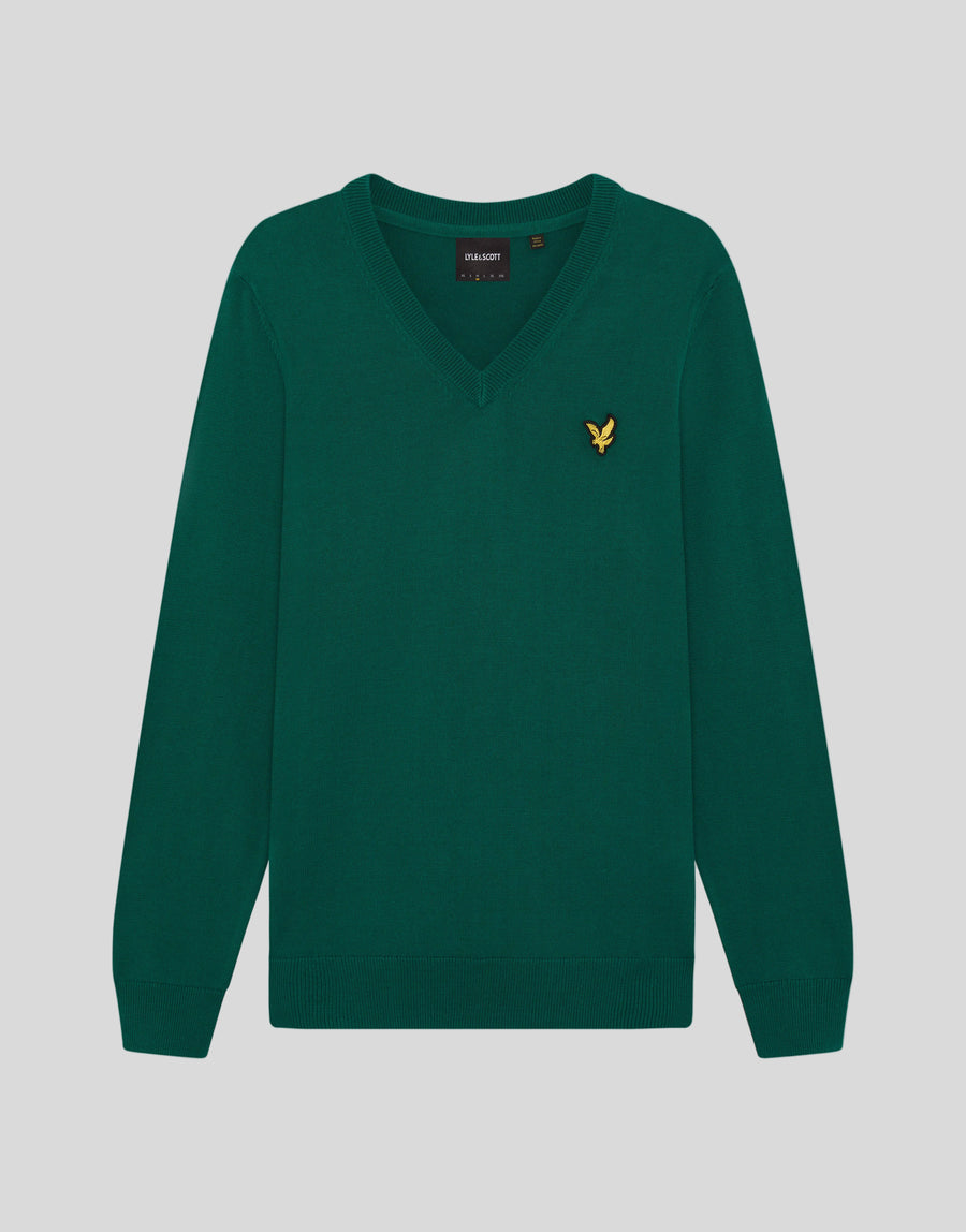 Man draagt een gebreide trui met V-hals uit de Archive-collectie onder een groene jas