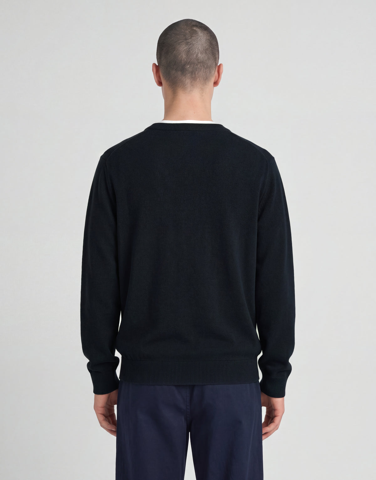 Mann trägt einen gestrickten Pullover mit V-Ausschnitt aus der „Archive“-Kollektion in Dunkelblau