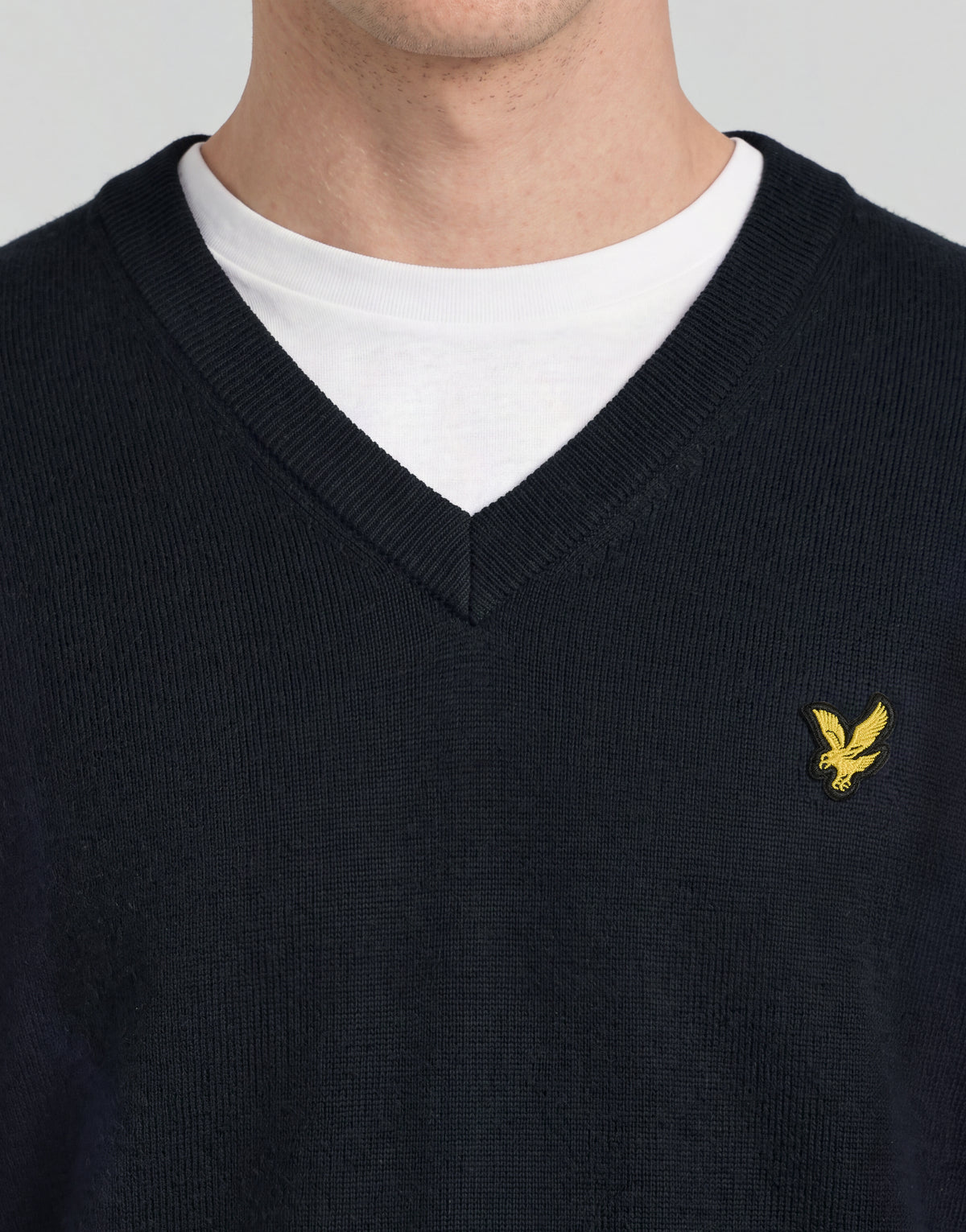 Mann trägt einen gestrickten Pullover mit V-Ausschnitt aus der „Archive“-Kollektion in Dunkelblau