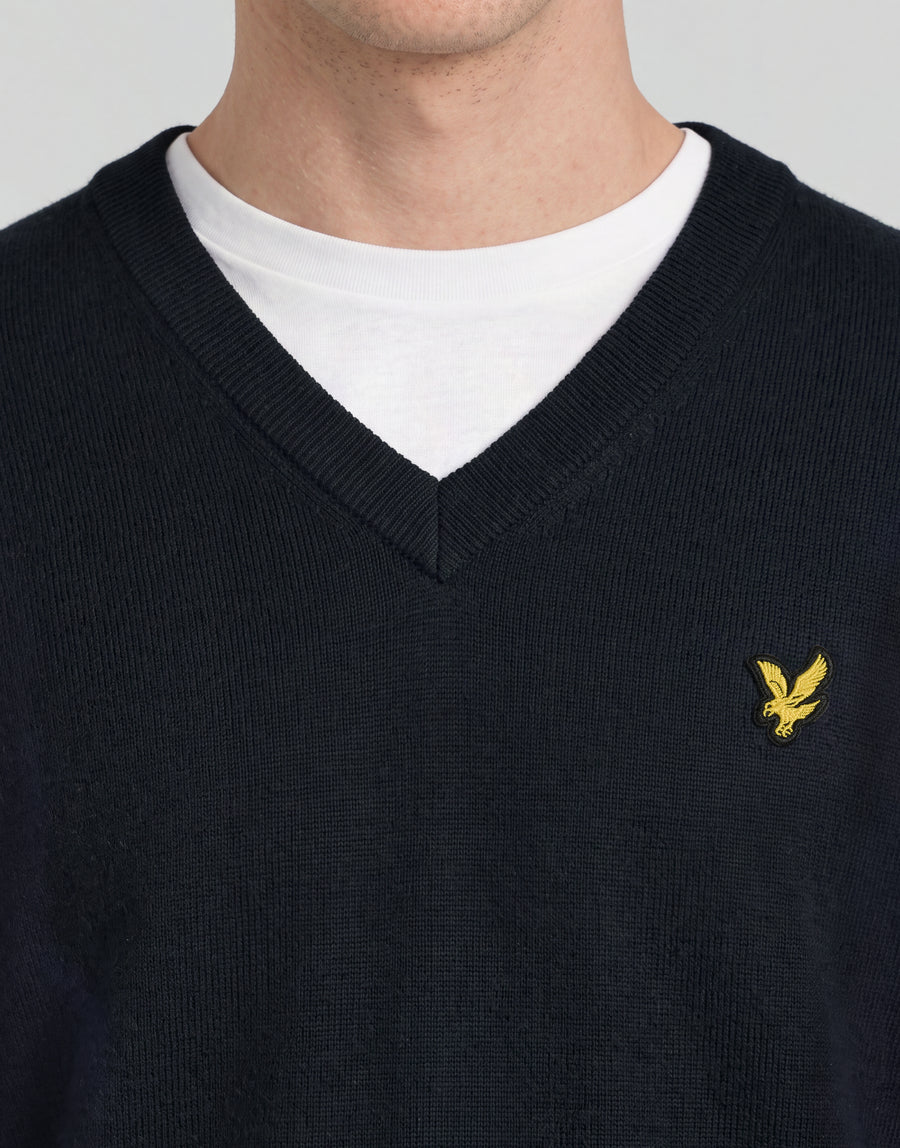 Mann trägt einen gestrickten Pullover mit V-Ausschnitt aus der „Archive“-Kollektion in Dunkelblau