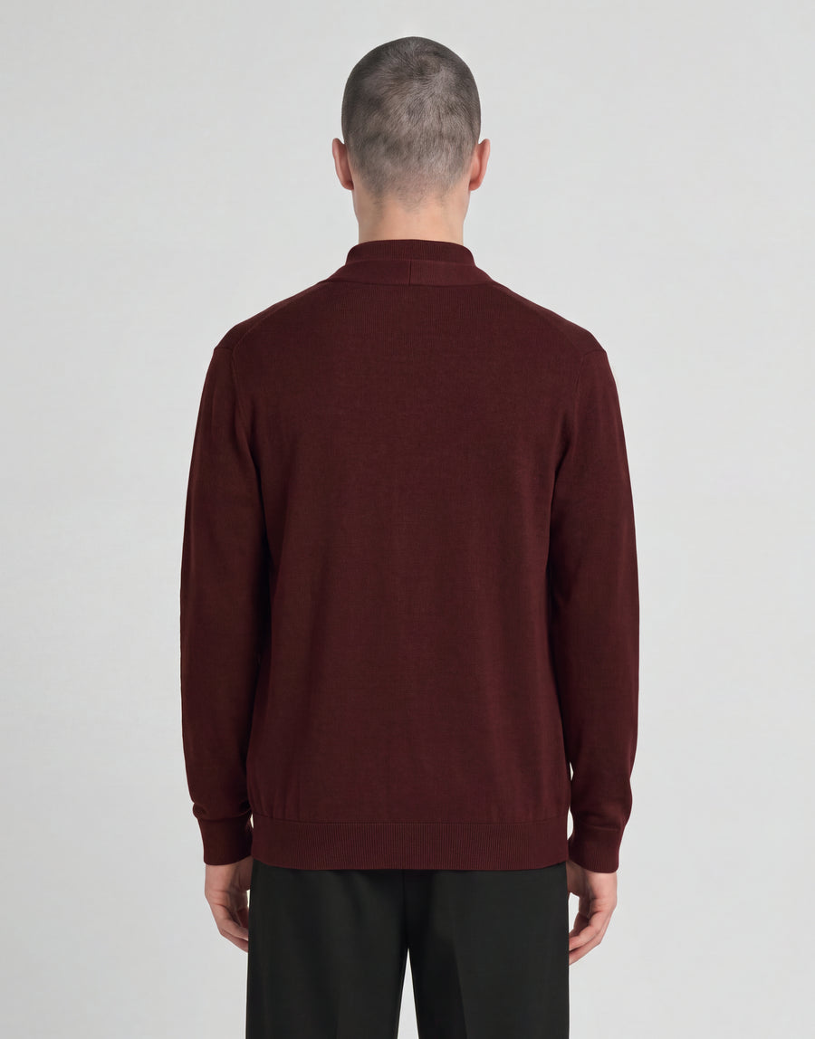 Man wears Archive Knitted Classic Cardigan in Claret Jug