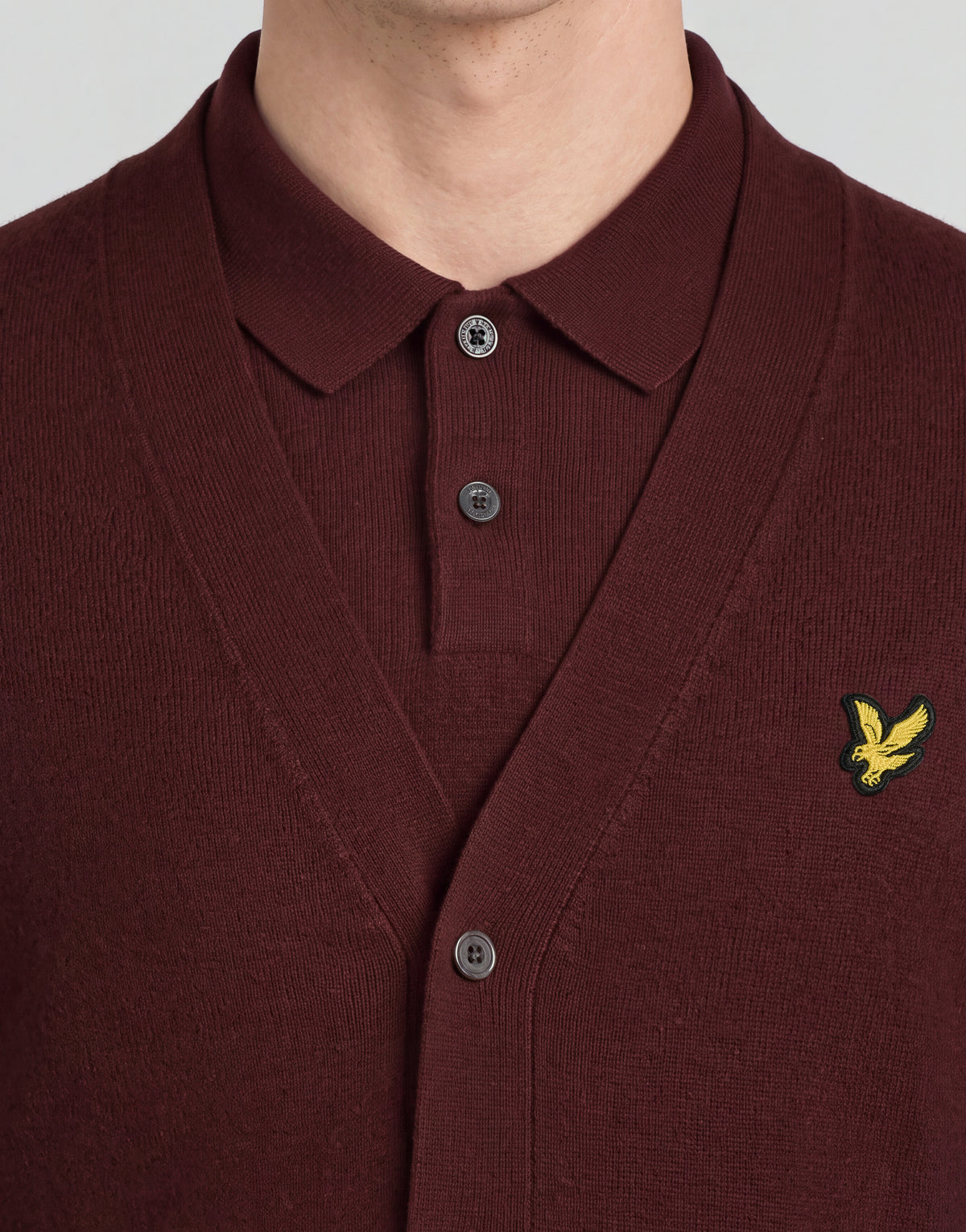 Man wears Archive Knitted Classic Cardigan in Claret Jug
