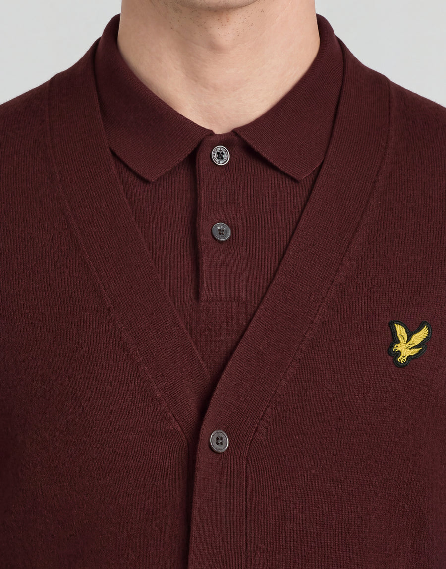 Man wears Archive Knitted Classic Cardigan in Claret Jug