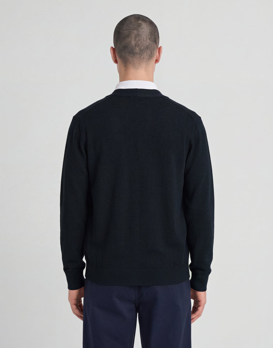 Mann trägt eine gestrickte „Classic Cardigan“ aus der „Archive“-Kollektion in Dunkelblau