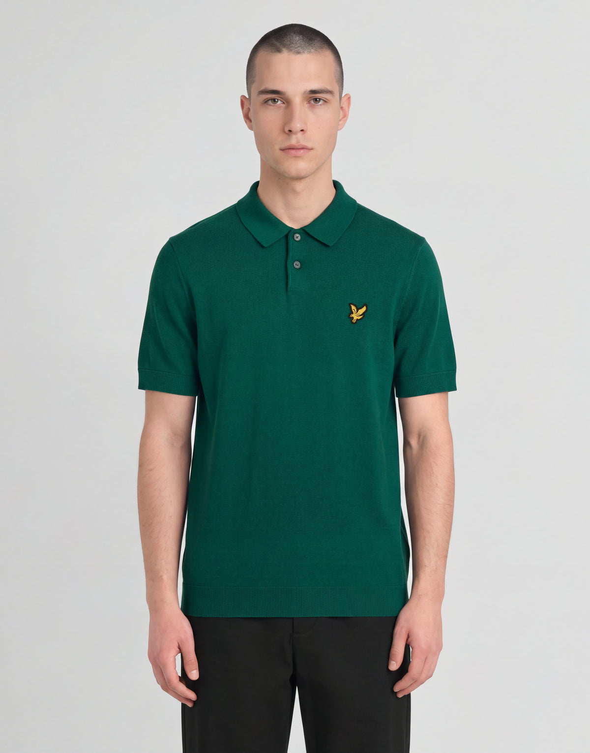 Un uomo indossa una polo lavorata a maglia della linea Archive con una giacca verde