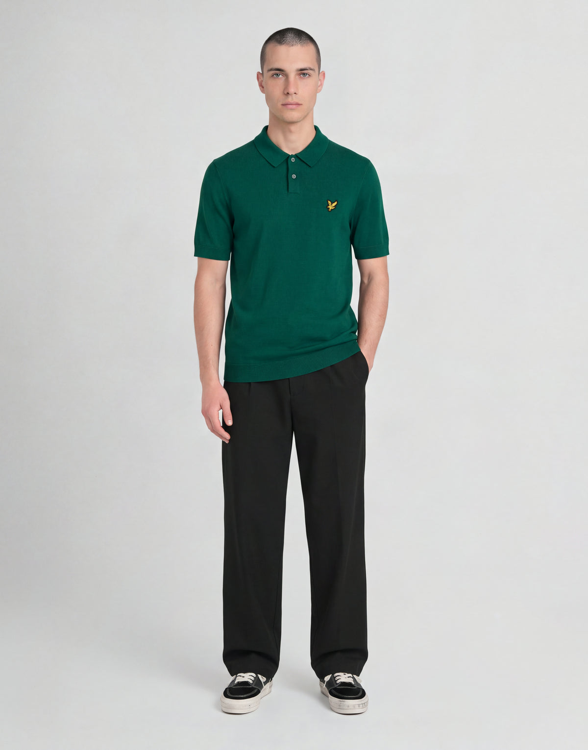 Un uomo indossa una polo lavorata a maglia della linea Archive con una giacca verde