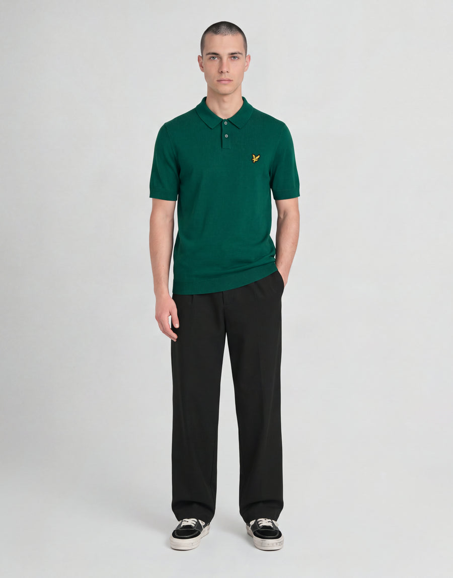 Un uomo indossa una polo lavorata a maglia della linea Archive con una giacca verde