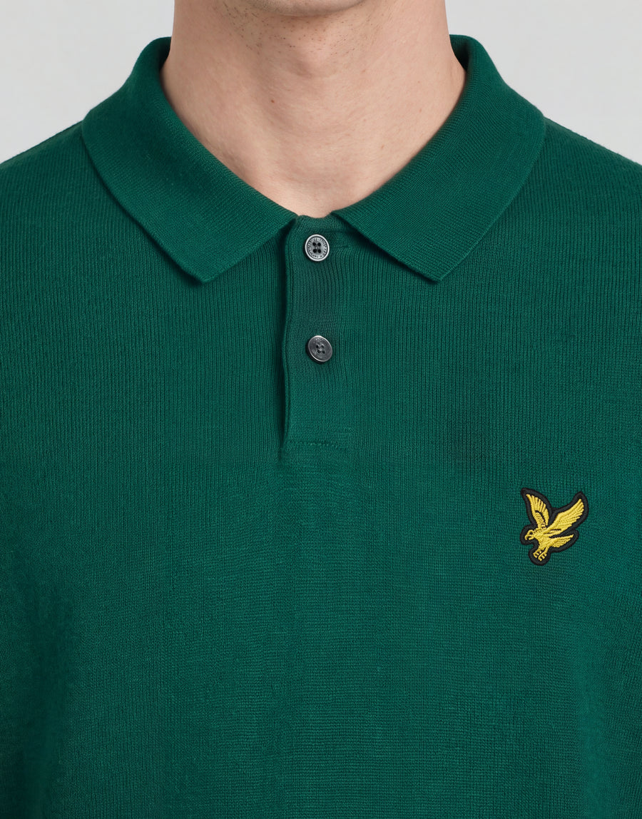 Un uomo indossa una polo lavorata a maglia della linea Archive con una giacca verde