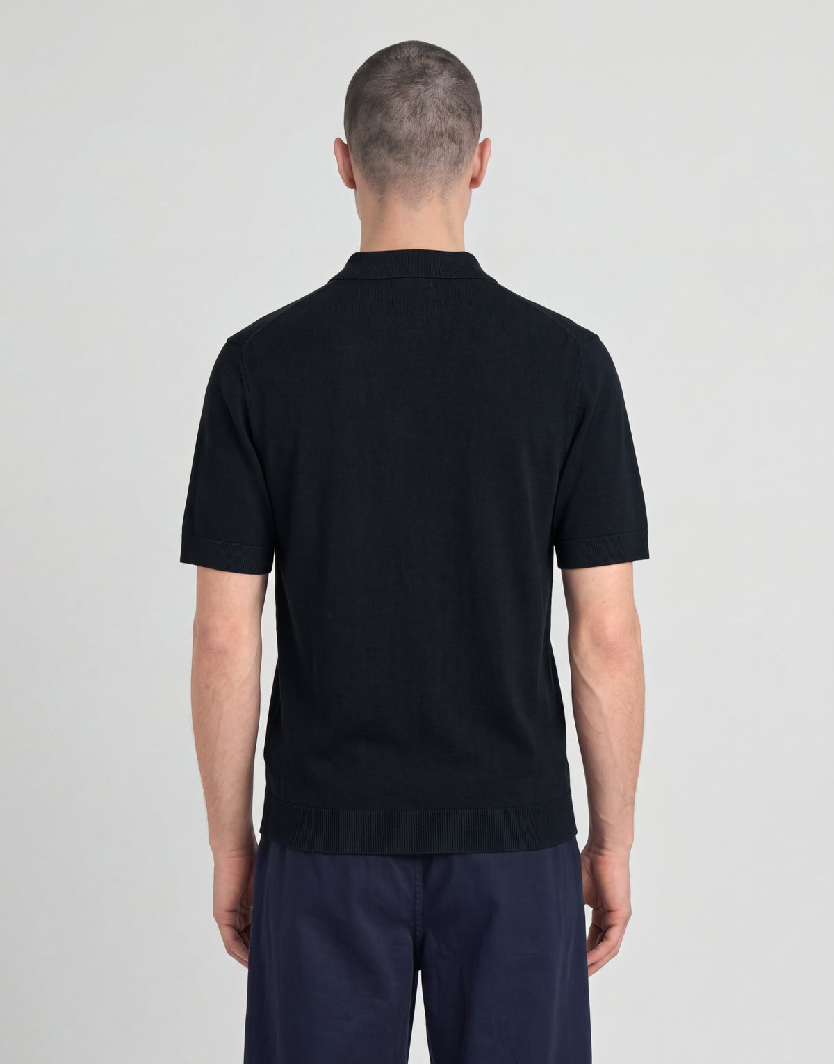 Man wears Archive Knitted Polo Shirt in Dark Navy
