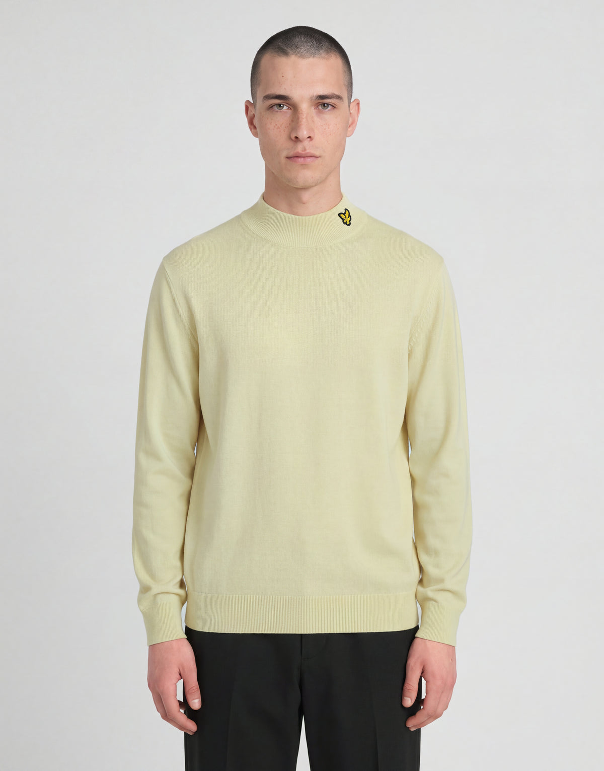 Man bär en stickad turtlenecktröja från kollektionen ”Archive” i nyansen ”Muted Ivory”