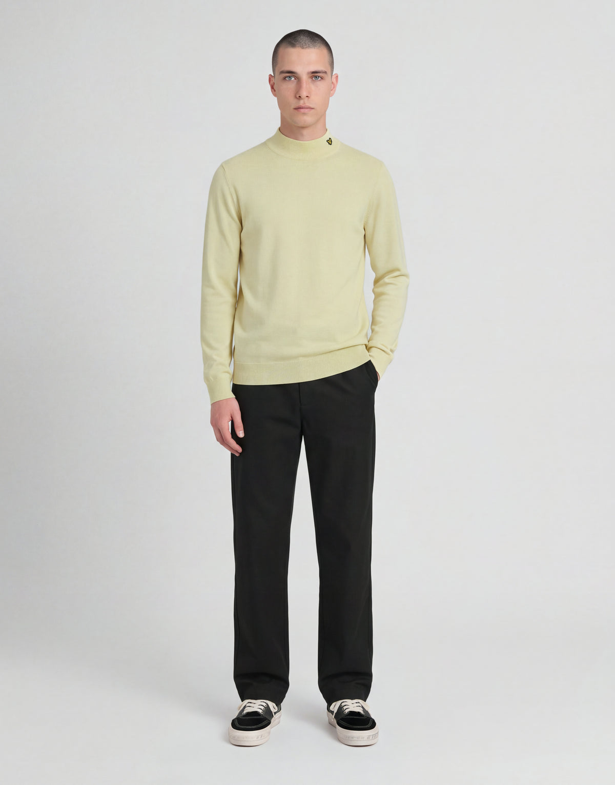 Man bär en stickad turtlenecktröja från kollektionen ”Archive” i nyansen ”Muted Ivory”