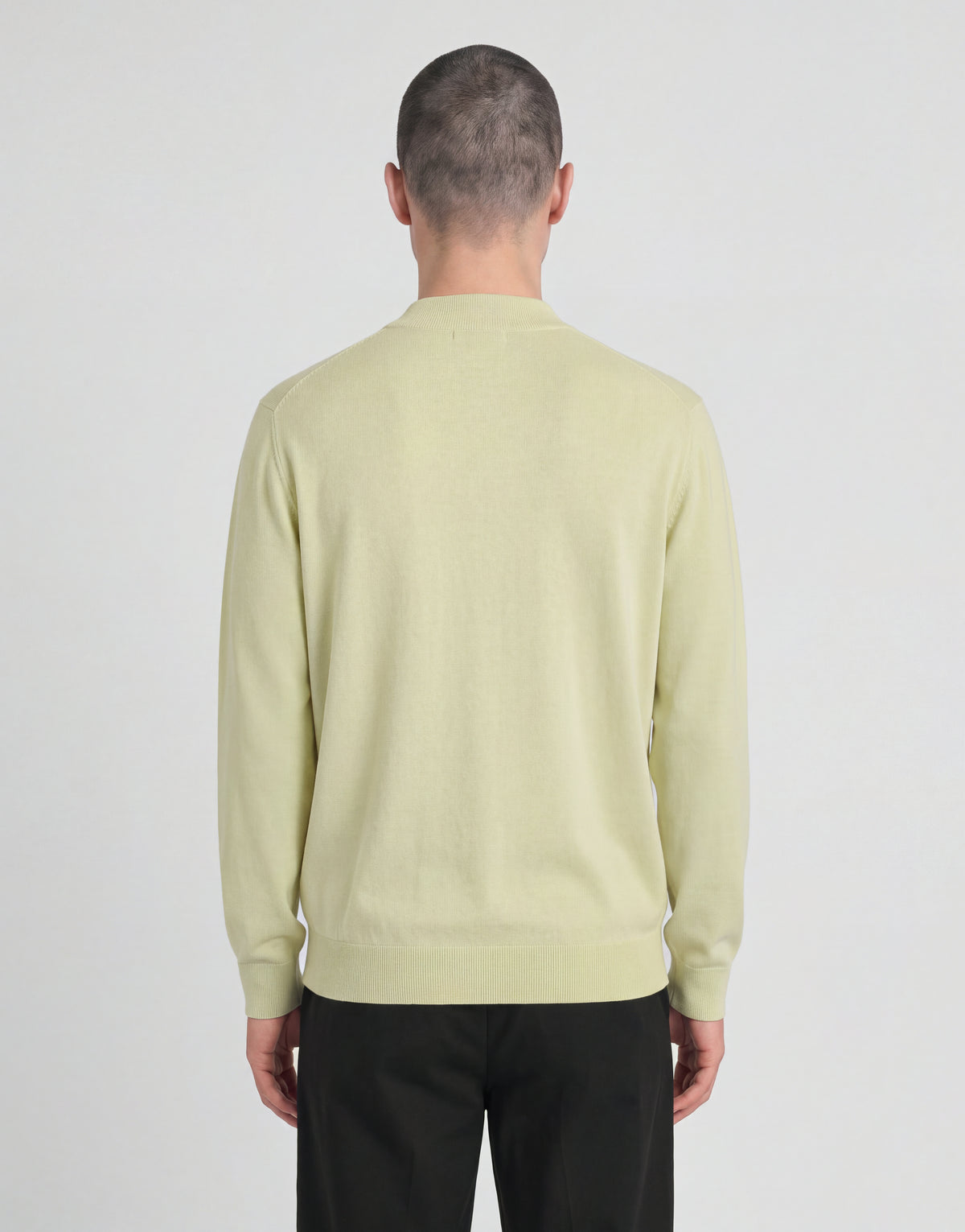Man bär en stickad turtlenecktröja från kollektionen ”Archive” i nyansen ”Muted Ivory”