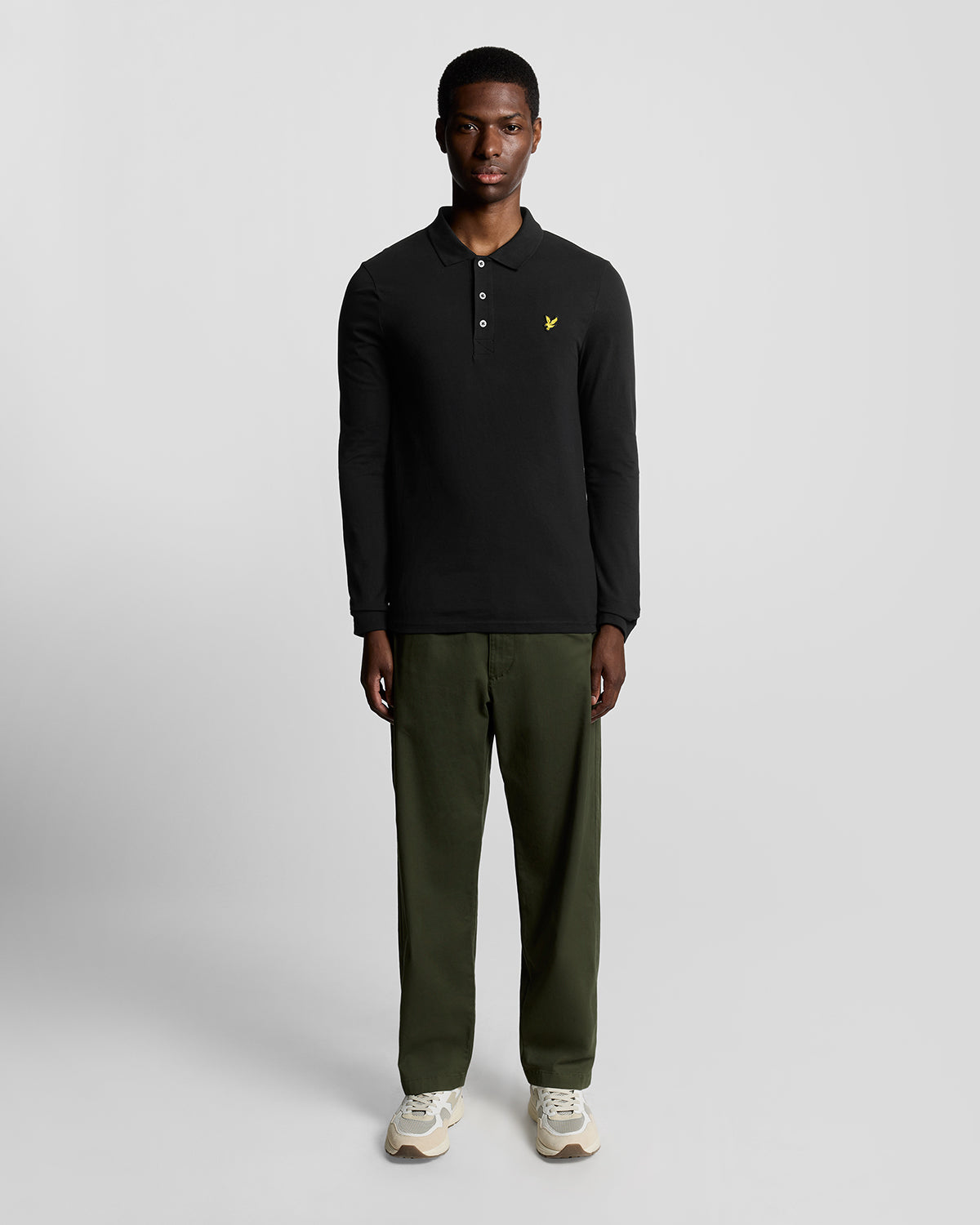 Homme portant un polo en coton à manches longues, couleur noir de jais