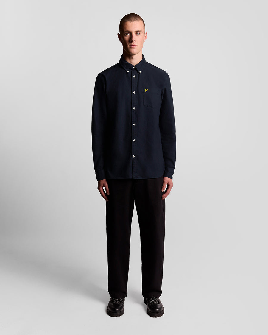 Un homme porte une chemise Oxford en coton à boutons, bleu marine foncé