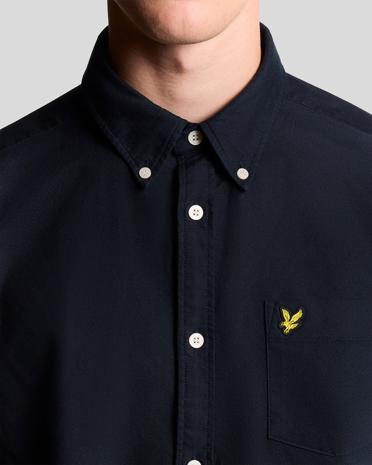Un homme porte une chemise Oxford en coton à boutons, bleu marine foncé