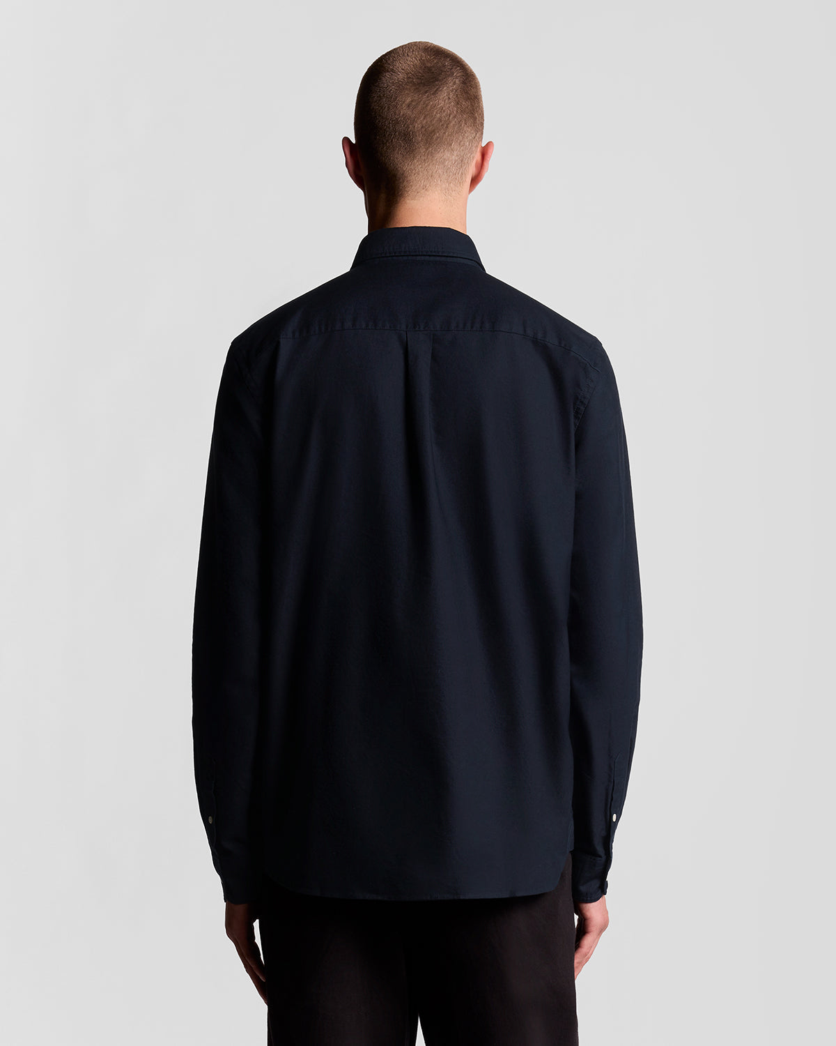 Un homme porte une chemise Oxford en coton à boutons, bleu marine foncé