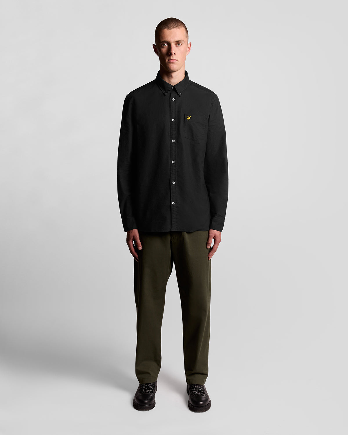 Un homme porte une chemise Oxford en coton à boutons, couleur noir de jais