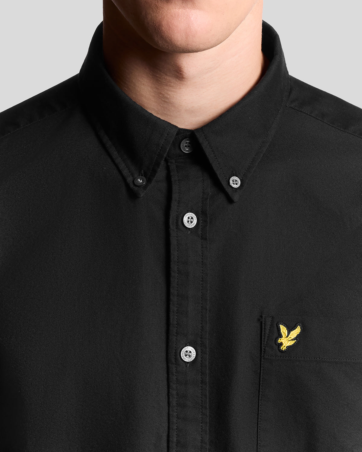 Un homme porte une chemise Oxford en coton à boutons, couleur noir de jais