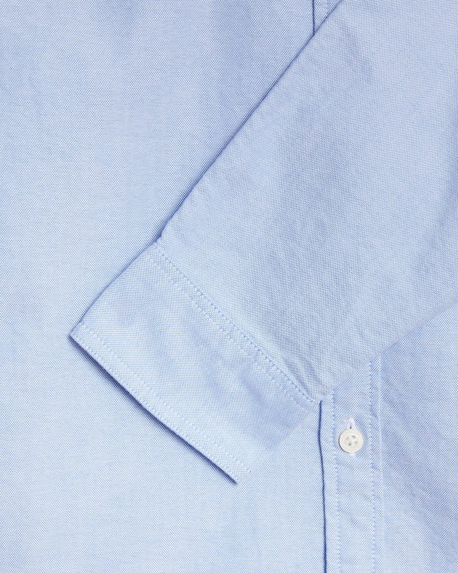 Un uomo indossa una camicia Oxford in cotone con bottoni sul colletto, modello Riviera