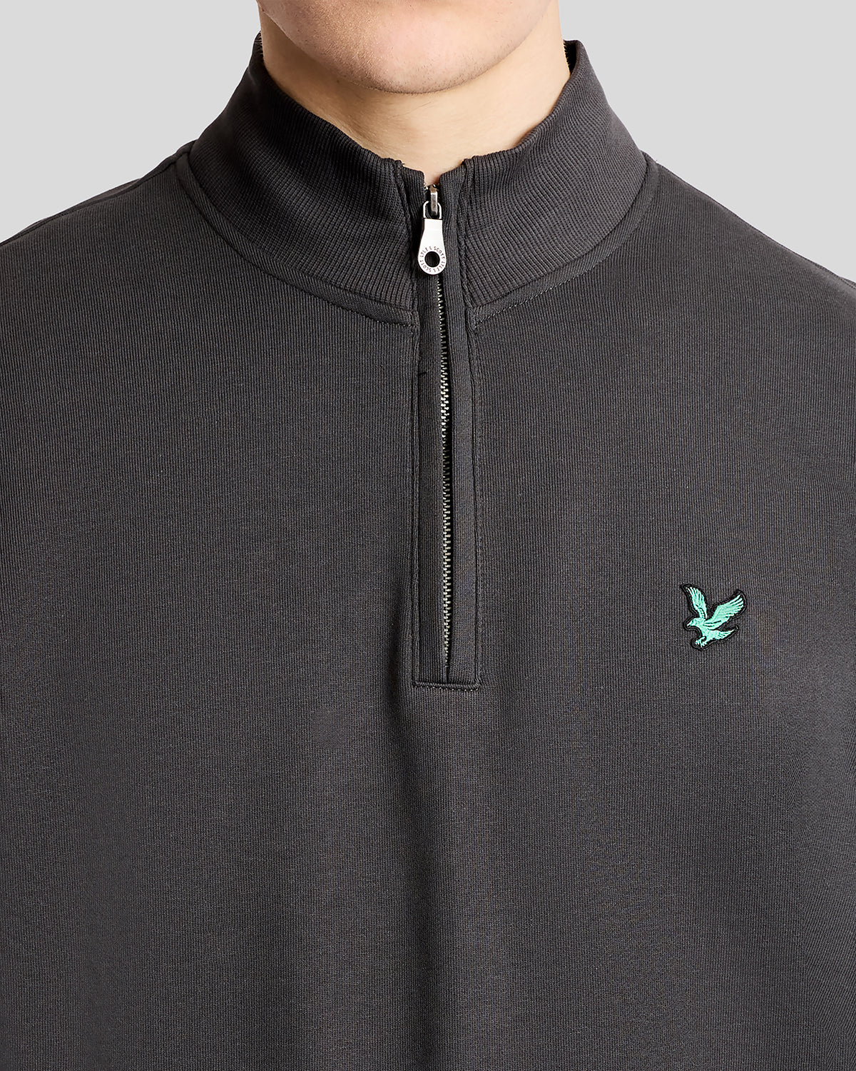 Mann trägt ein „Green Eagle Cotton 1/4 Zip Midlayer“-Shirt in der Farbe „Gunmetal“