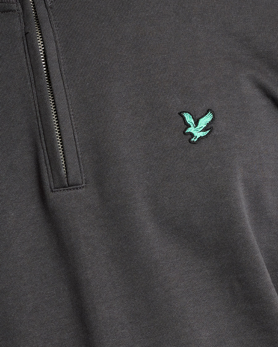 Mann trägt ein „Green Eagle Cotton 1/4 Zip Midlayer“-Shirt in der Farbe „Gunmetal“