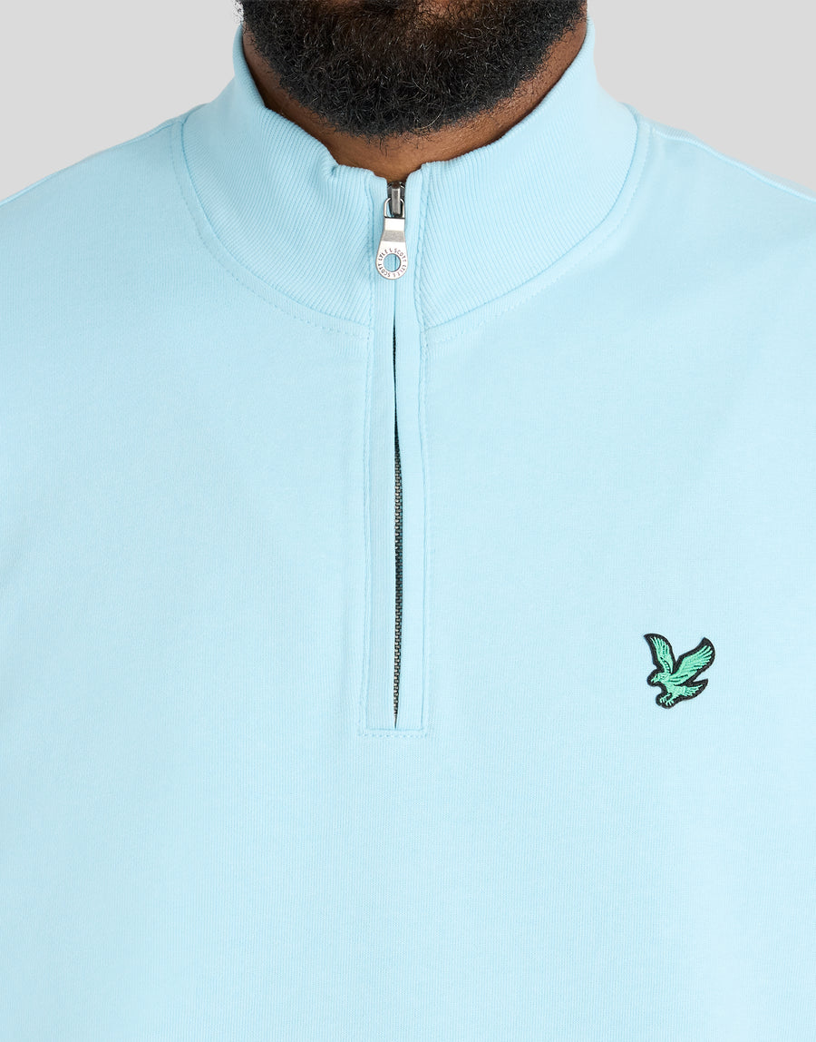 Mann trägt ein „Green Eagle Cotton 1/4 Zip Midlayer“-Shirt in der Farbe „Sea Breeze Blue“