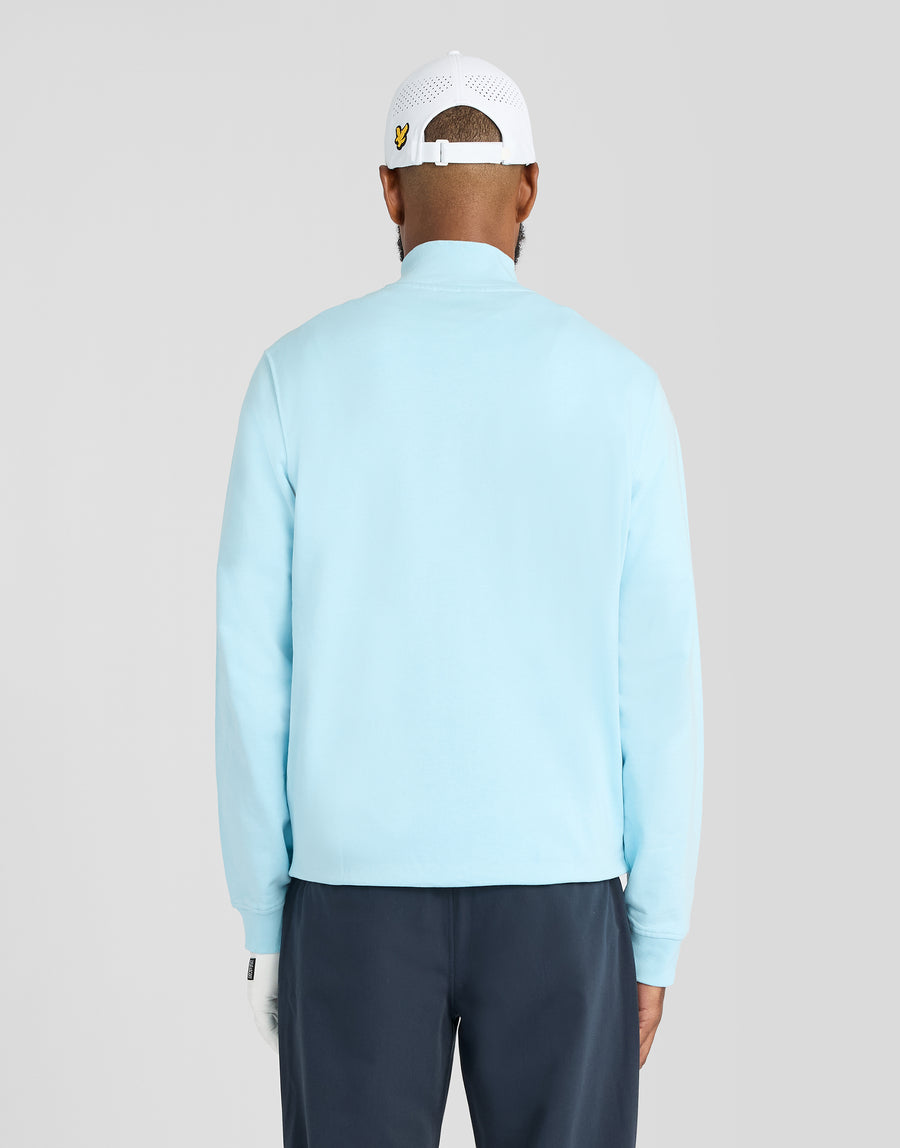 Mann trägt ein „Green Eagle Cotton 1/4 Zip Midlayer“-Shirt in der Farbe „Sea Breeze Blue“