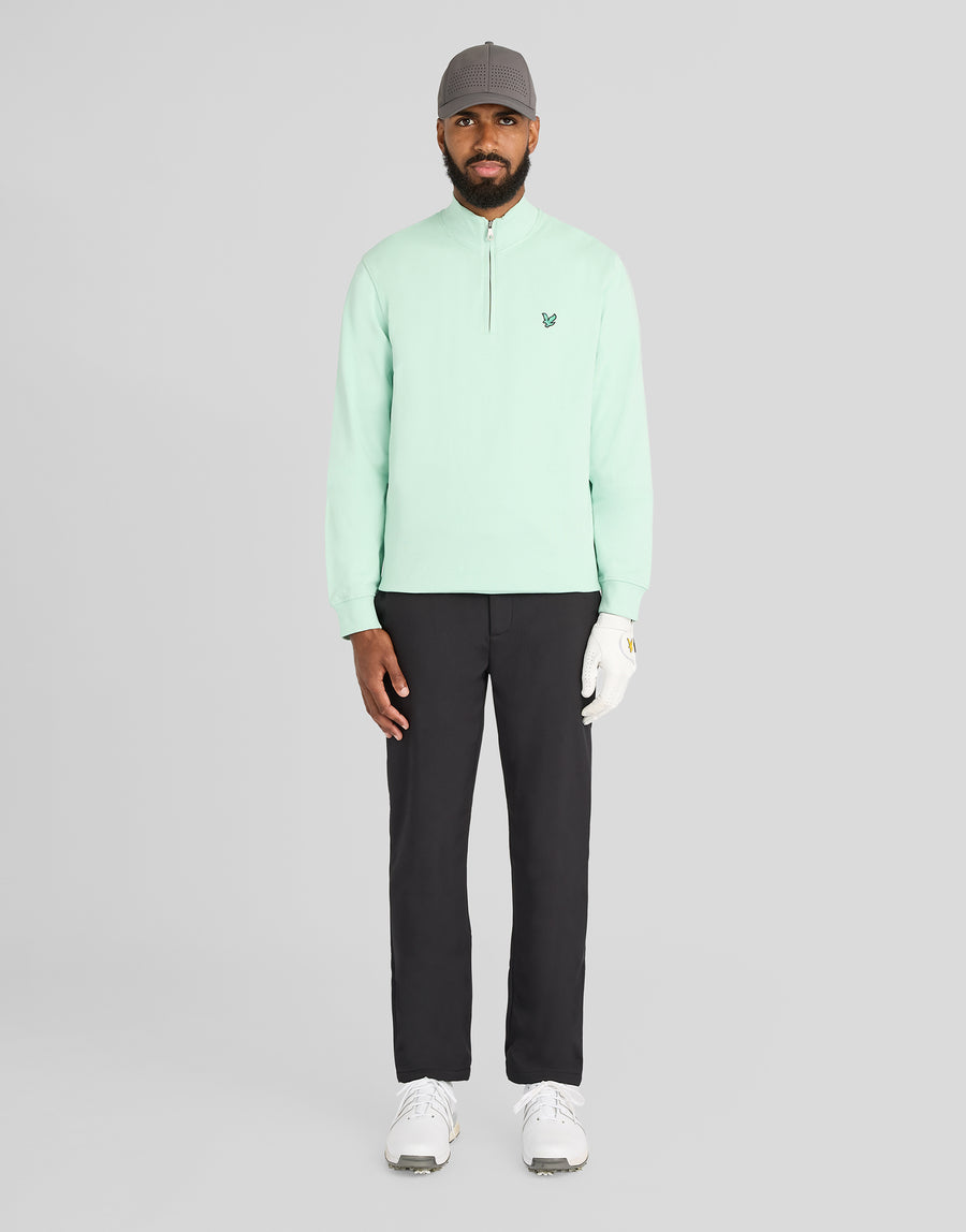 Mann trägt ein „Green Eagle Cotton 1/4 Zip Midlayer“-Shirt in der Farbe „Morning Mint“